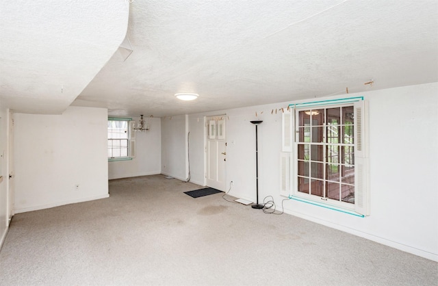 below grade area with baseboards, carpet, and a textured ceiling