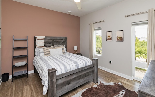 bedroom with ceiling fan, baseboards, multiple windows, and wood finished floors