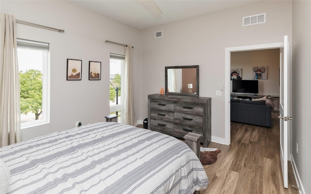 bedroom featuring visible vents, wood finished floors, and multiple windows