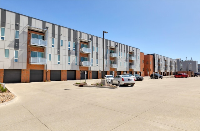 view of building exterior with cooling unit and uncovered parking