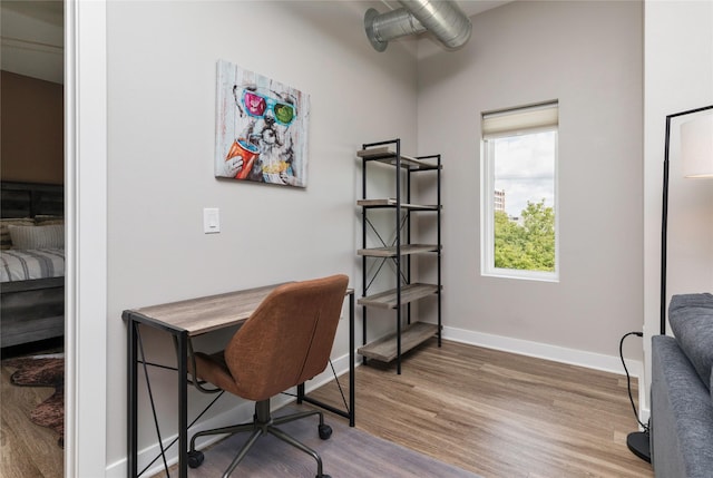 home office with baseboards and wood finished floors