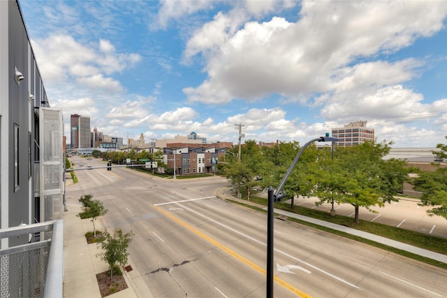 view of street with a view of city, sidewalks, curbs, and street lighting