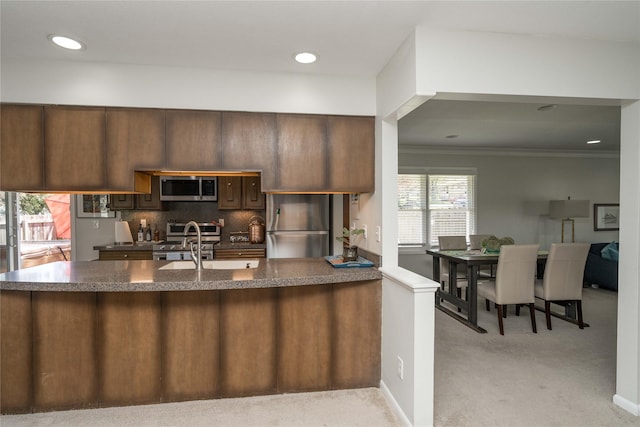 1233 24th St, West Des Moines, IA 50266 - kitchen with appliances with stainless steel finishes, light carpet, dark countertops, crown molding, and recessed lighting