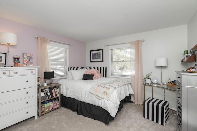 bedroom with multiple windows and light carpet