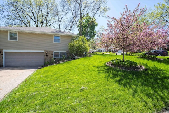 1233 24th St, West Des Moines, IA 50266 - view of grassy yard with an attached garage and concrete driveway
