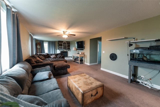 living area featuring a ceiling fan, a textured ceiling, baseboards, and carpet