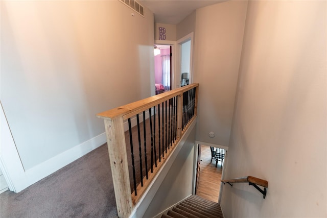 stairway with visible vents, carpet flooring, and baseboards