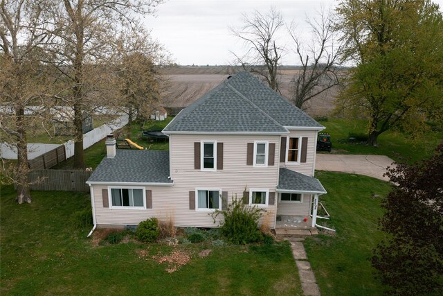 223 E Belmont St, Milo, IA 50166 - back of property featuring roof with shingles, fence, a chimney, and a yard