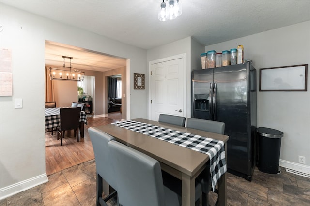 dining space with baseboards and an inviting chandelier