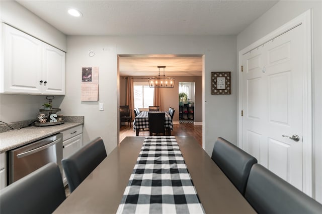 dining space featuring recessed lighting, a textured ceiling, an inviting chandelier, and wood finished floors