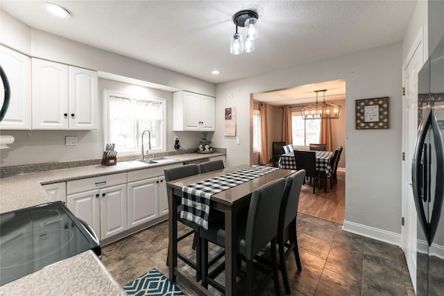 kitchen featuring a sink, light countertops, white cabinetry, recessed lighting, and black appliances