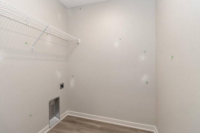 laundry area featuring baseboards, laundry area, electric dryer hookup, and wood finished floors