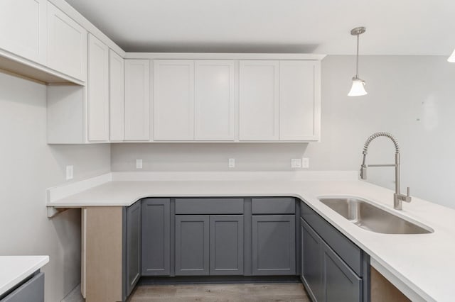 kitchen featuring a sink, white cabinets, and light countertops