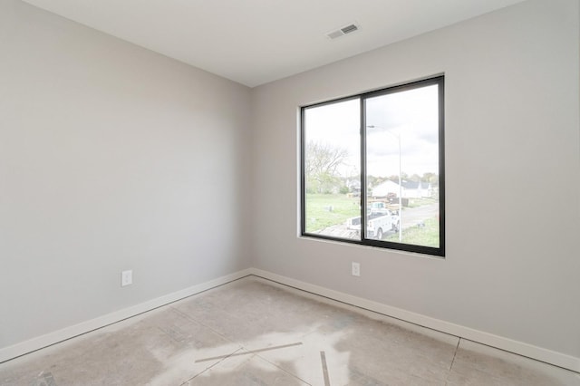 spare room with baseboards, unfinished concrete flooring, and visible vents