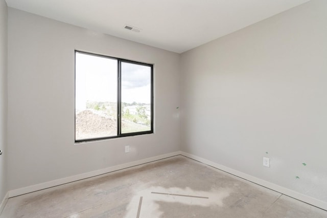 spare room with baseboards, visible vents, and unfinished concrete flooring