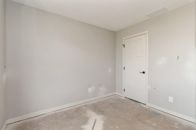 unfurnished room with baseboards, unfinished concrete flooring, and visible vents
