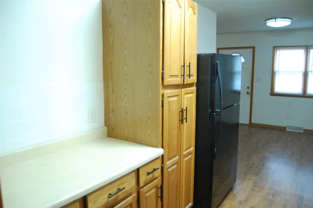 kitchen with freestanding refrigerator, visible vents, light wood finished floors, and light countertops