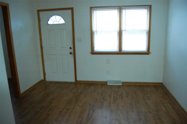 foyer entrance with baseboards, wood finished floors, and visible vents