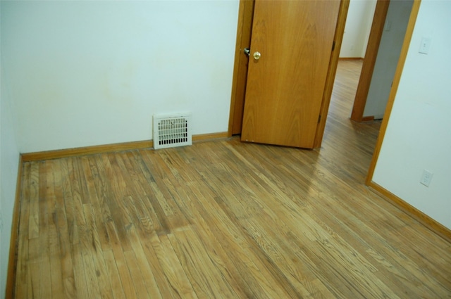 unfurnished room featuring baseboards, visible vents, and light wood-style flooring