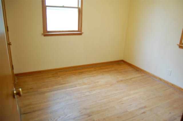unfurnished room featuring baseboards and light wood-style flooring