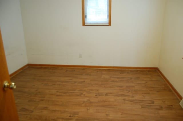 unfurnished room with baseboards and wood finished floors