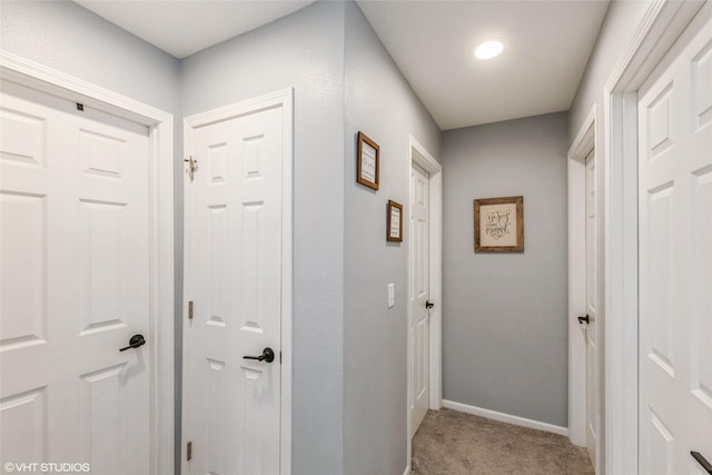 corridor with light carpet and baseboards