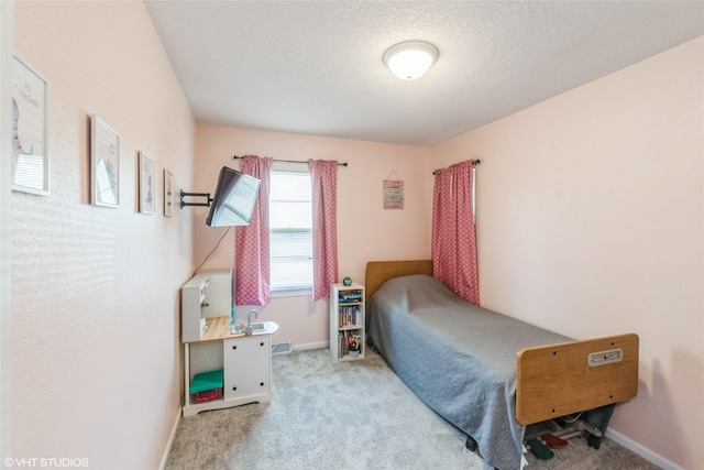 bedroom with carpet floors, a textured ceiling, and baseboards