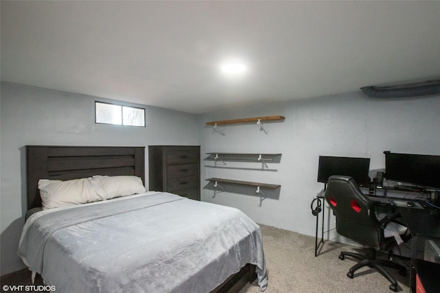 bedroom featuring light carpet and a desk