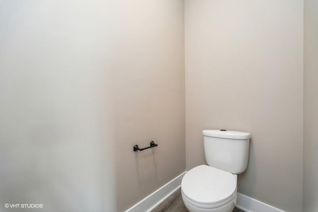 bathroom with baseboards and toilet