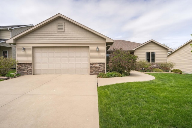 view of front facade with a garage, a front yard, driveway, and stone siding