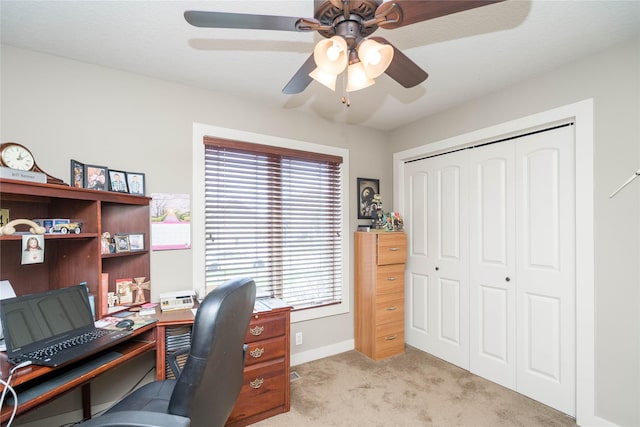 office space with a ceiling fan, baseboards, and carpet