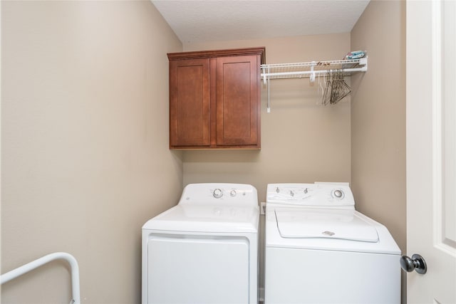 clothes washing area featuring separate washer and dryer and cabinet space