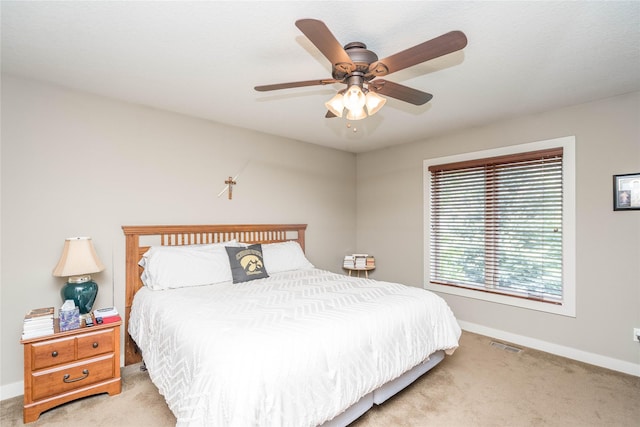 bedroom featuring baseboards, visible vents, light carpet, and ceiling fan