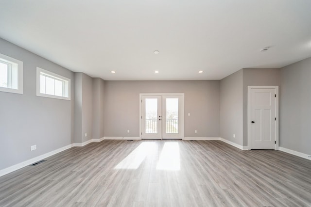 unfurnished living room with french doors, visible vents, wood finished floors, baseboards, and recessed lighting
