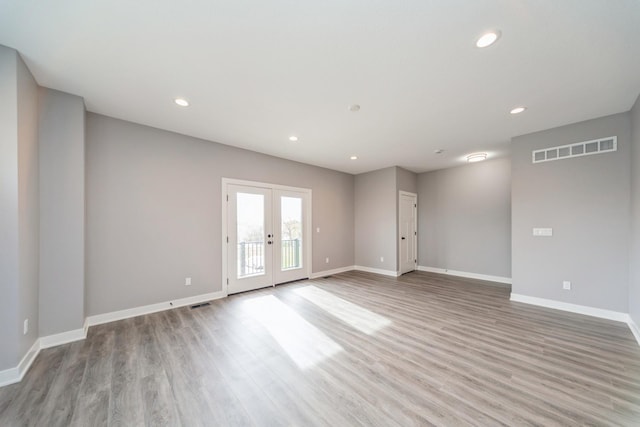 spare room featuring baseboards, visible vents, and light wood-type flooring