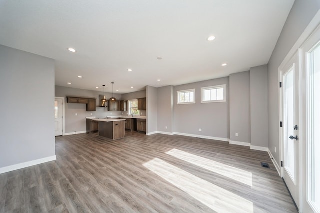 unfurnished living room with visible vents, recessed lighting, baseboards, and wood finished floors
