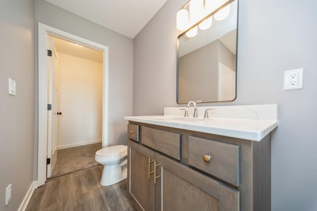 bathroom featuring vanity, baseboards, toilet, and wood finished floors