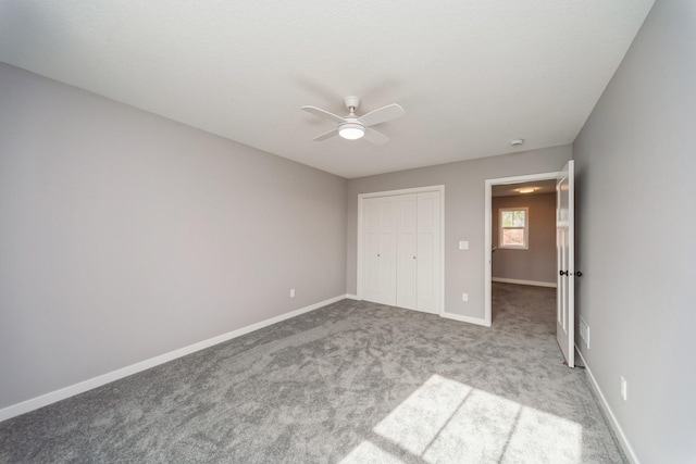 unfurnished bedroom with carpet floors, baseboards, ceiling fan, and a closet