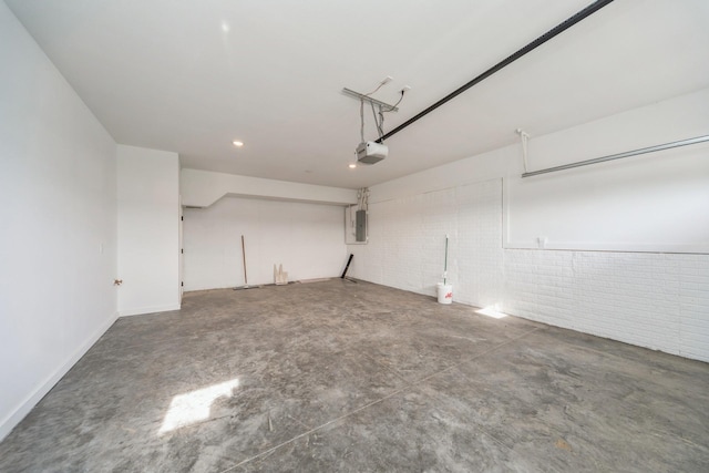 garage featuring a garage door opener, recessed lighting, and electric panel