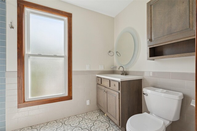 218 E Howard St, Colfax, IA 50054 - bathroom featuring vanity, tile walls, wainscoting, and toilet
