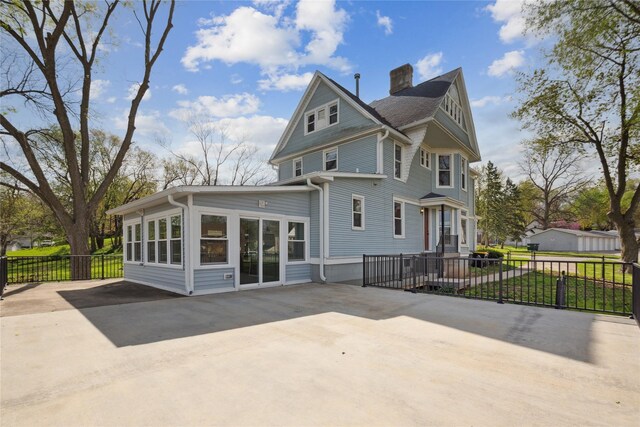 218 E Howard St, Colfax, IA 50054 - rear view of house featuring fence, a chimney, driveway, and a patio area