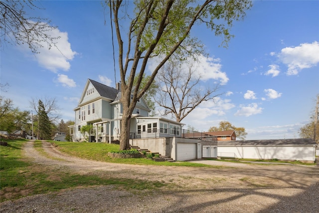 view of side of home with driveway and a wooden deck