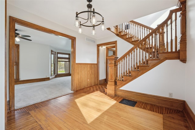 interior space with visible vents, wainscoting, wood walls, baseboards, and wood-type flooring