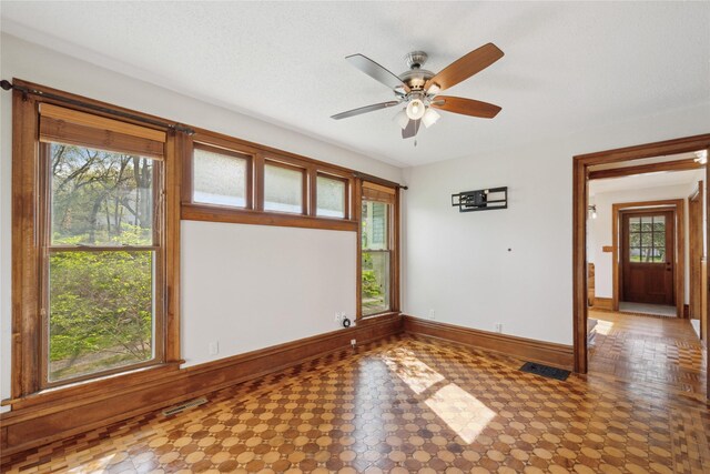 218 E Howard St, Colfax, IA 50054 - unfurnished room with baseboards, ceiling fan, tile patterned floors, and visible vents
