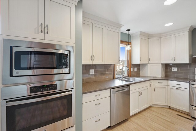 218 E Howard St, Colfax, IA 50054 - kitchen featuring backsplash, white cabinetry, appliances with stainless steel finishes, and a sink
