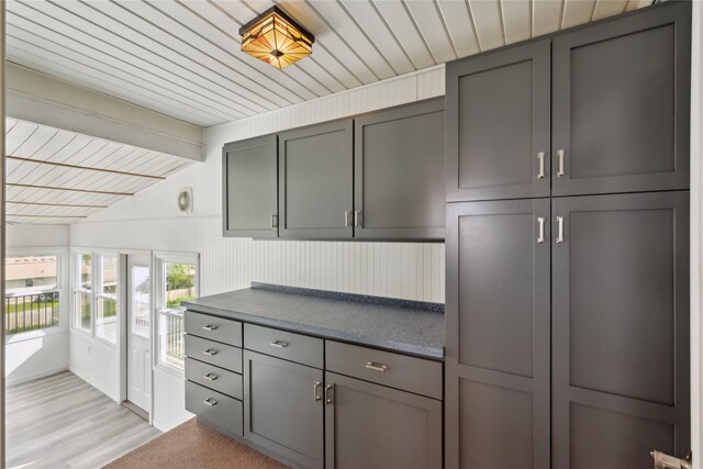 218 E Howard St, Colfax, IA 50054 - kitchen with gray cabinetry, dark countertops, wood ceiling, and light wood finished floors
