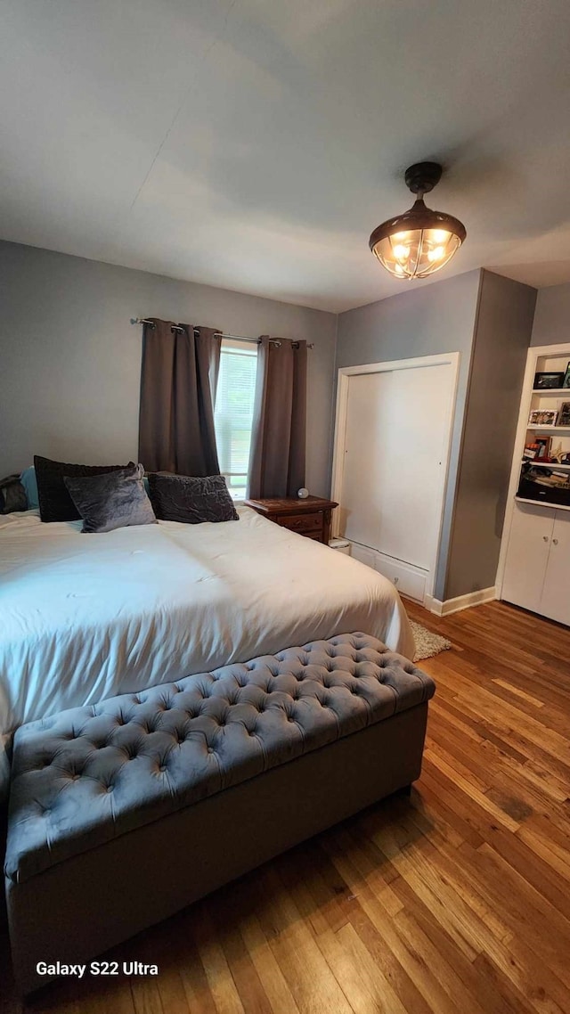 bedroom with baseboards, a baseboard radiator, and hardwood / wood-style floors