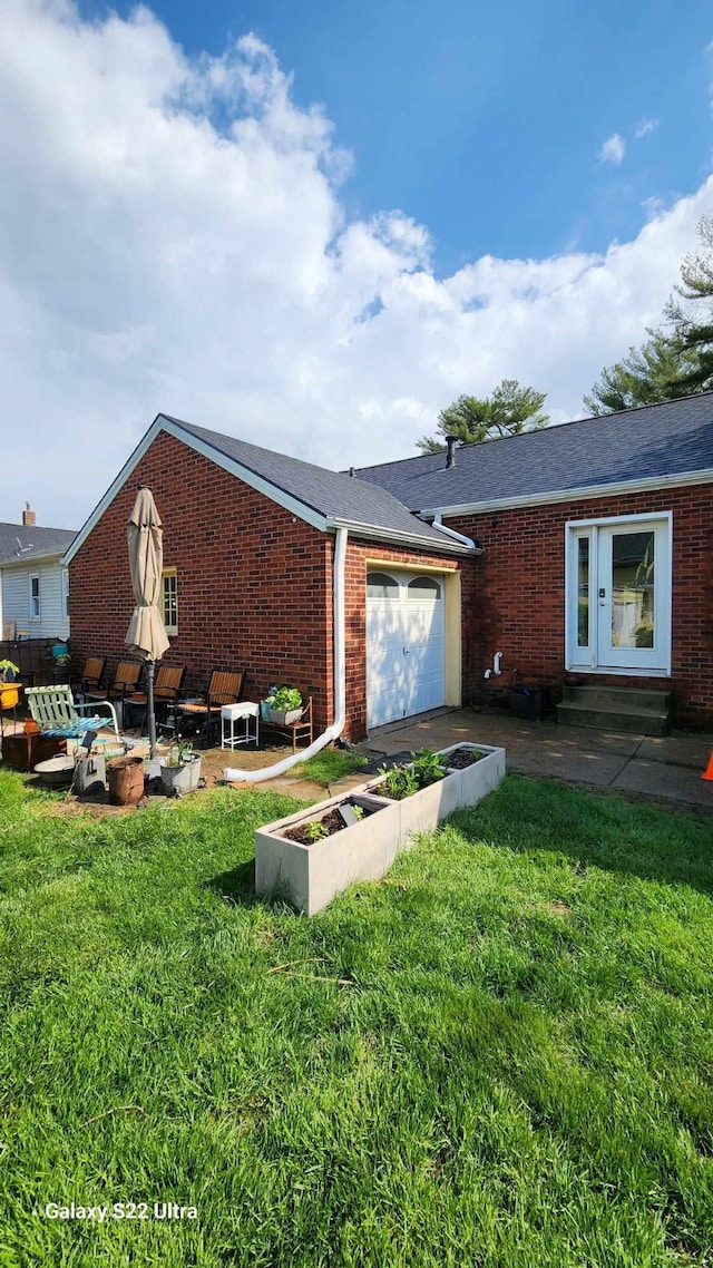 exterior space with brick siding, an attached garage, and a front lawn