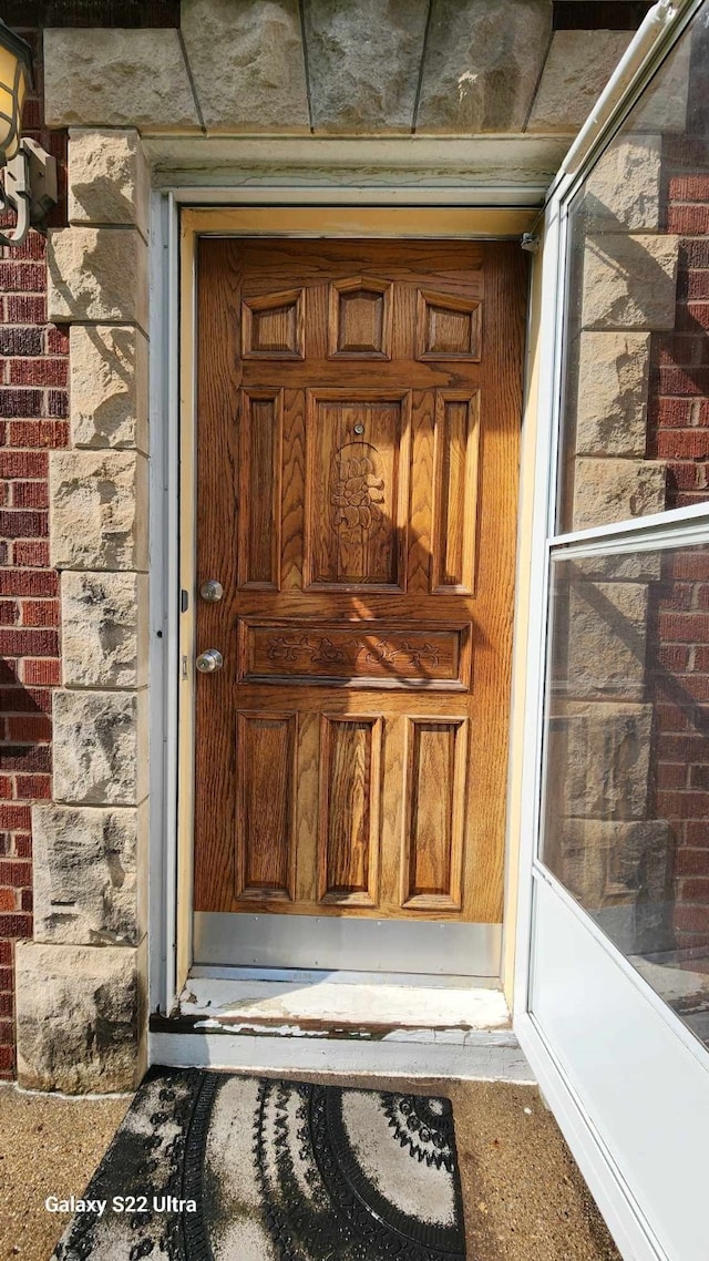 doorway to property featuring brick siding
