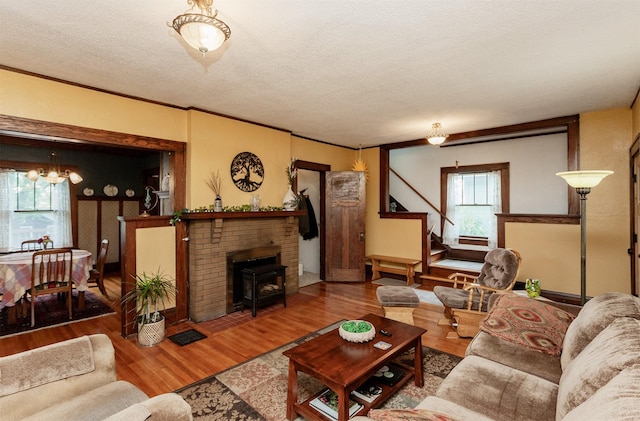 living area featuring a textured ceiling, wood finished floors, a chandelier, and stairway